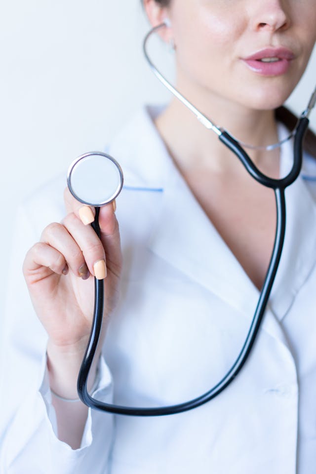 Doctor in white coat holding a stethoscope, symbolizing healthcare and medical professions.